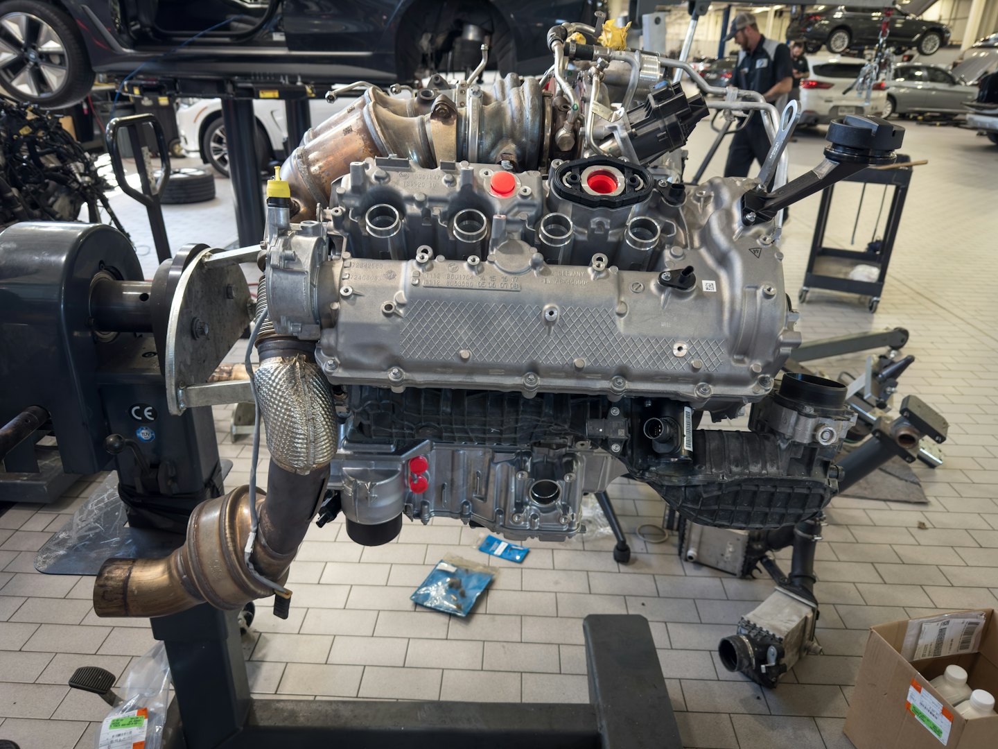 Disassembled engine on a stand in a repair shop.